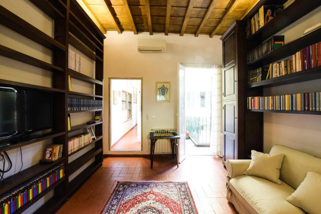 a living room with a couch and bookshelves at Casa Ghibellina - city center with outdoor space! in Florence