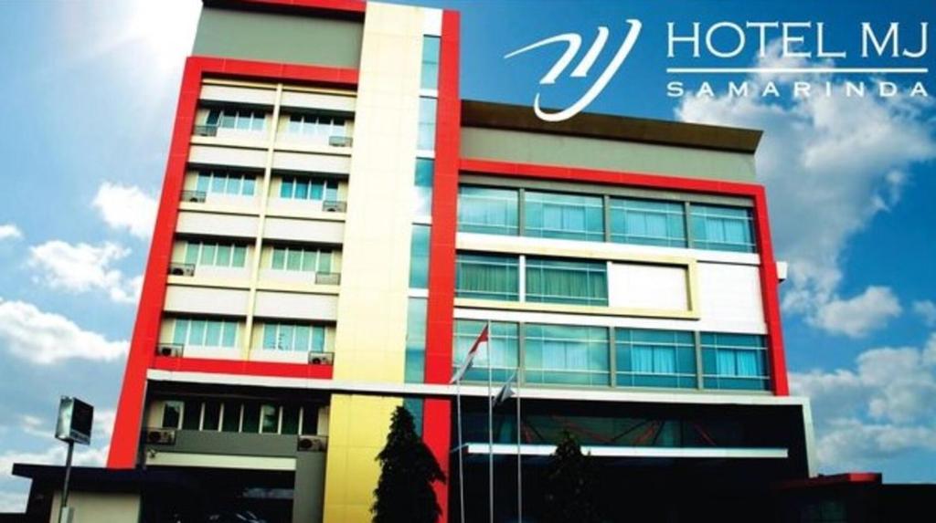 un edificio de hotel con un cartel en el costado en Hotel MJ en Samarinda