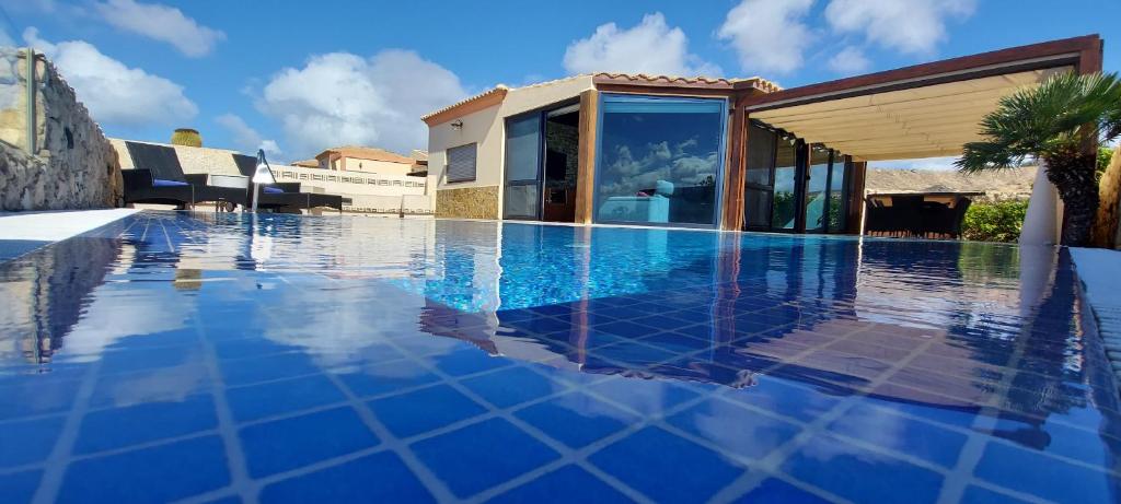 una piscina con piastrelle blu su una casa di VILLA LOBA WITH PRIVATE POOL a Costa Calma
