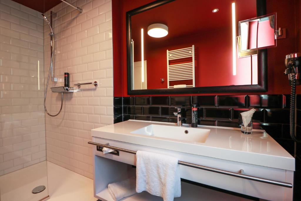 a bathroom with a sink and a mirror at Hotel Haverkamp in Bremerhaven