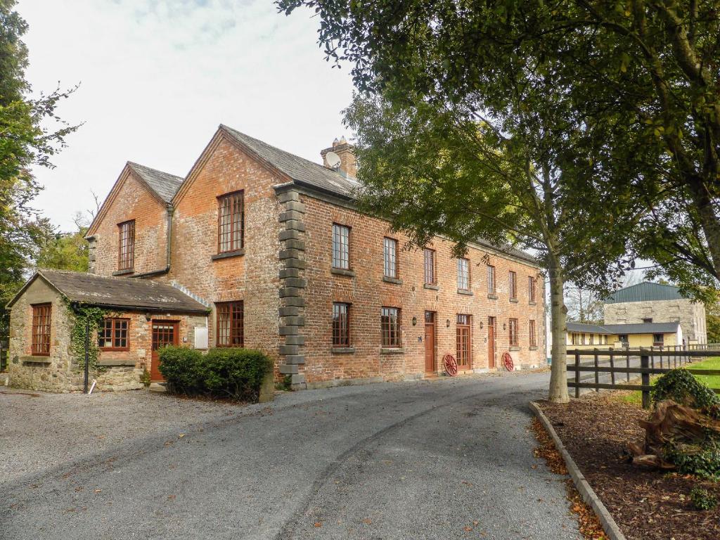 a large brick building with a road in front of it at The Coach House in Piltown