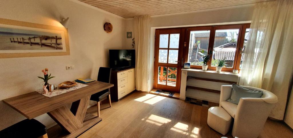 a living room with a television and a table and a chair at Ferienwohnung 2 mittig in Vogtareuth Rinser in Vogtareuth