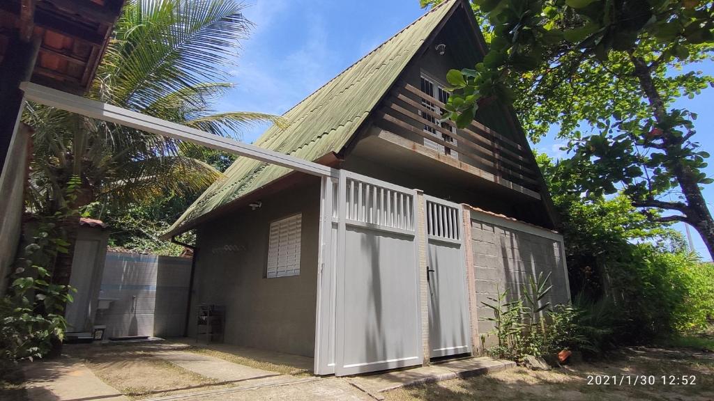 uma casa com uma porta branca ao lado dela em Chale da Dalva em Ubatuba