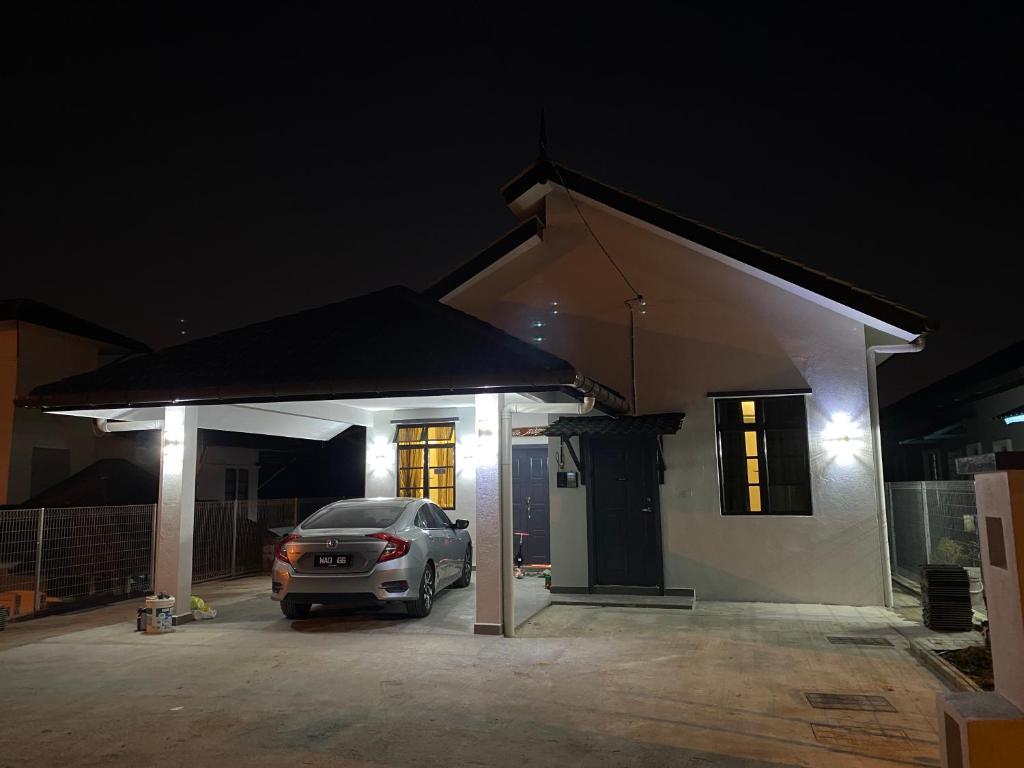 Bangi Utara Villa في كاجانغ: سيارة متوقفة أمام منزل في الليل