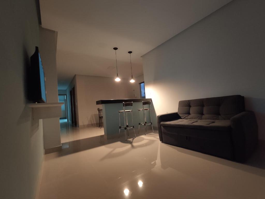 a living room with a couch and a bar at Apartamento One 360° in Capitólio