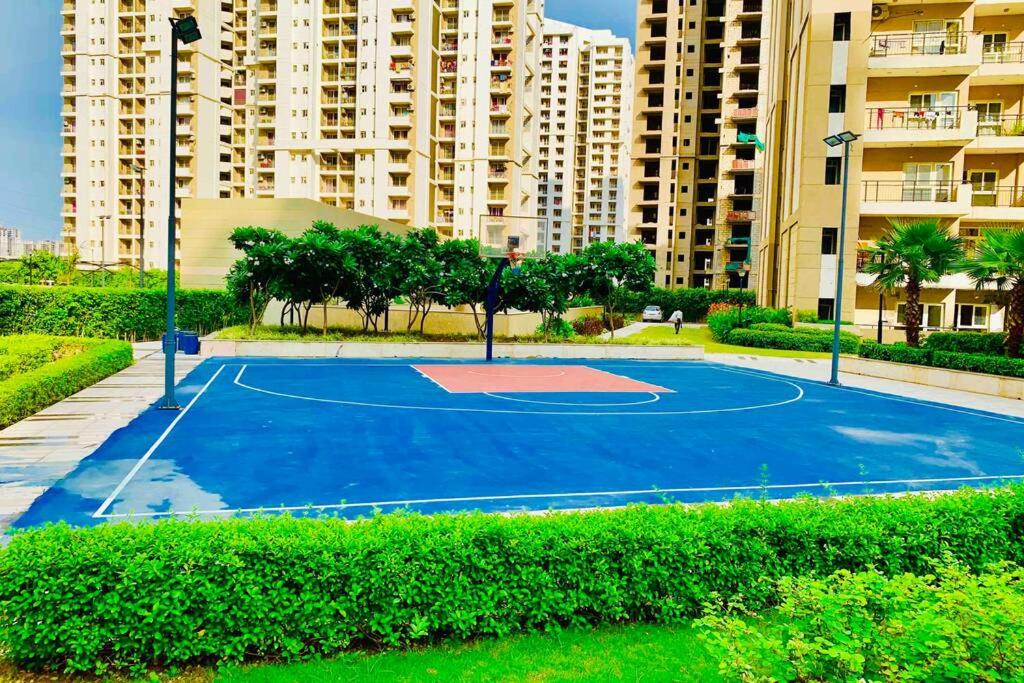 a basketball court in front of a apartment complex at The Friend’s Square near IndiaExpo Mart in Noida
