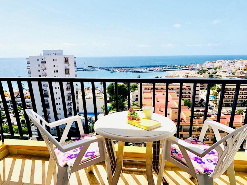 ロス・クリスティアーノスにあるAmazing views to Los Cristianos Bay in Achacayのテーブルと椅子、海の景色を望むバルコニー