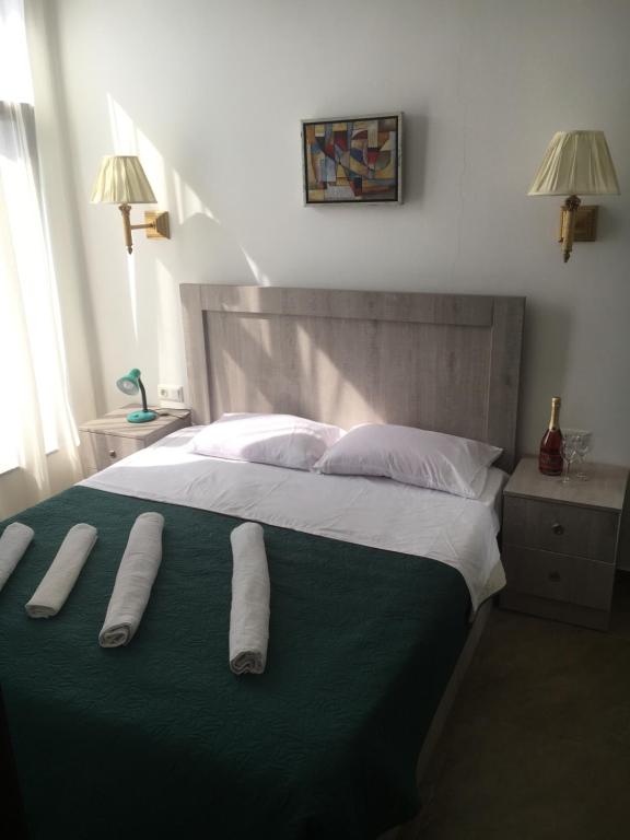 a bed with two pairs of towels on it at Aparthotel Family in Ureki