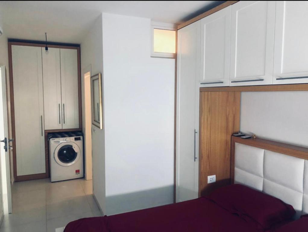a room with a bed and a washing machine at Beach Luxury Apartment Shëngjin in Lezhë