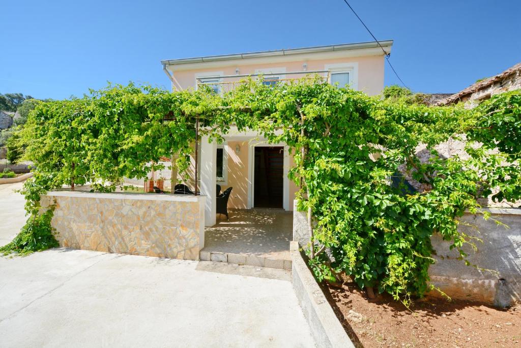 a house with an ivy covered entry way at Apartmani Nina in Tkon