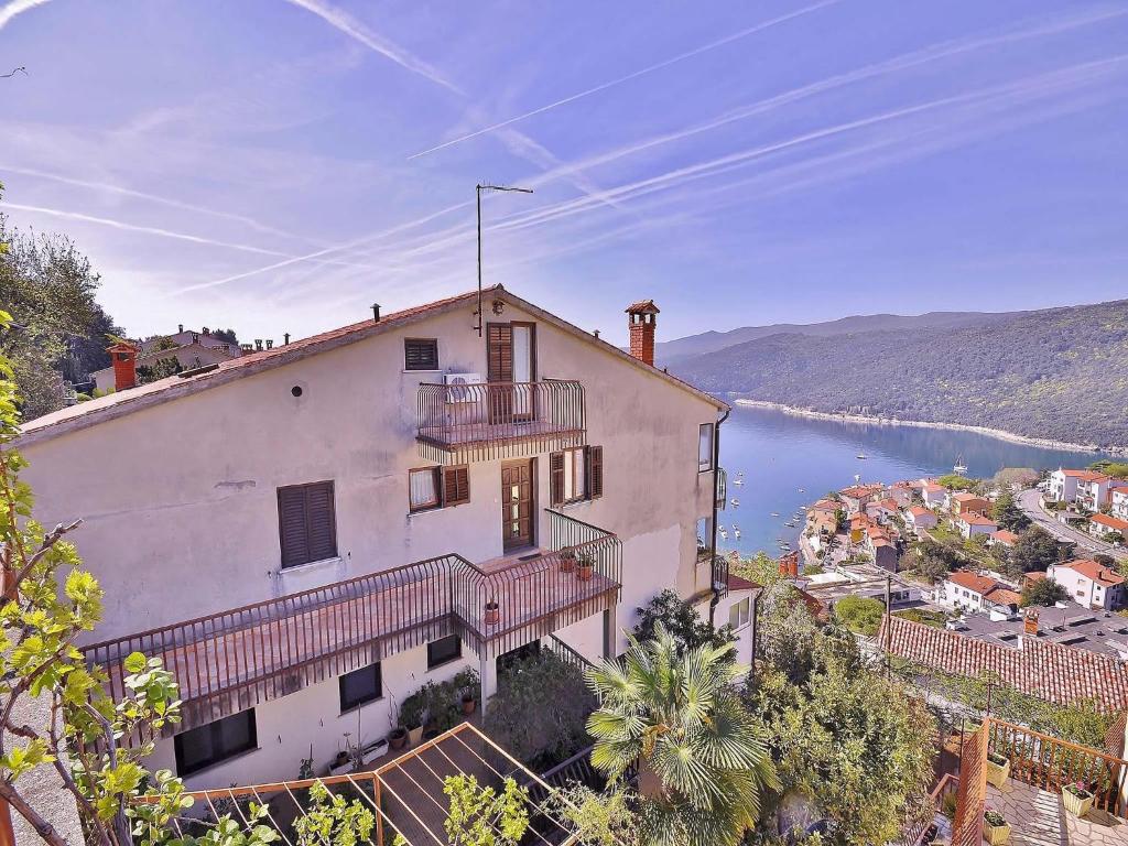 a large white building with balconies and a body of water at Apartments Adriana in Rabac