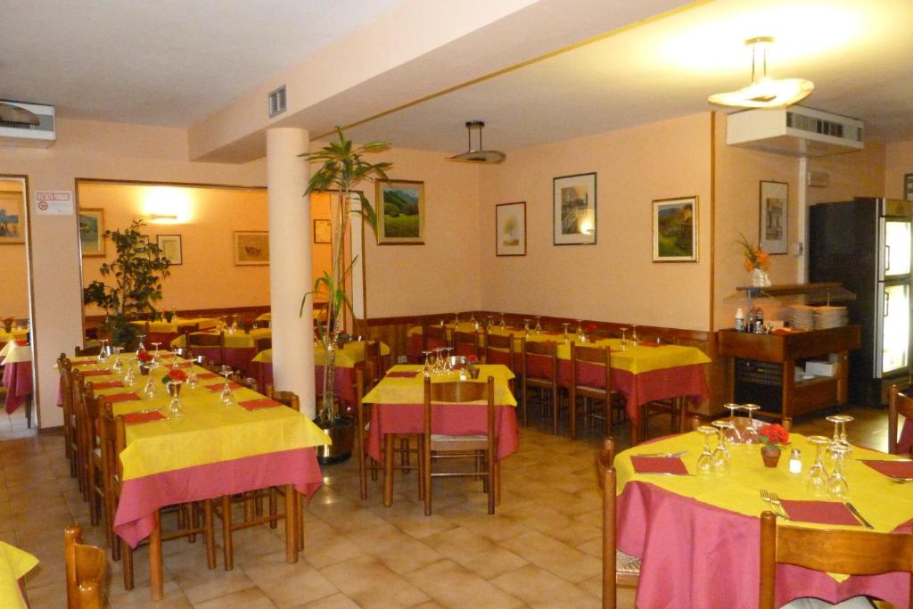 ein Restaurant mit Tischen mit gelben und rosa Tischdecken in der Unterkunft Albergo Ristorante Gori in Ameglia