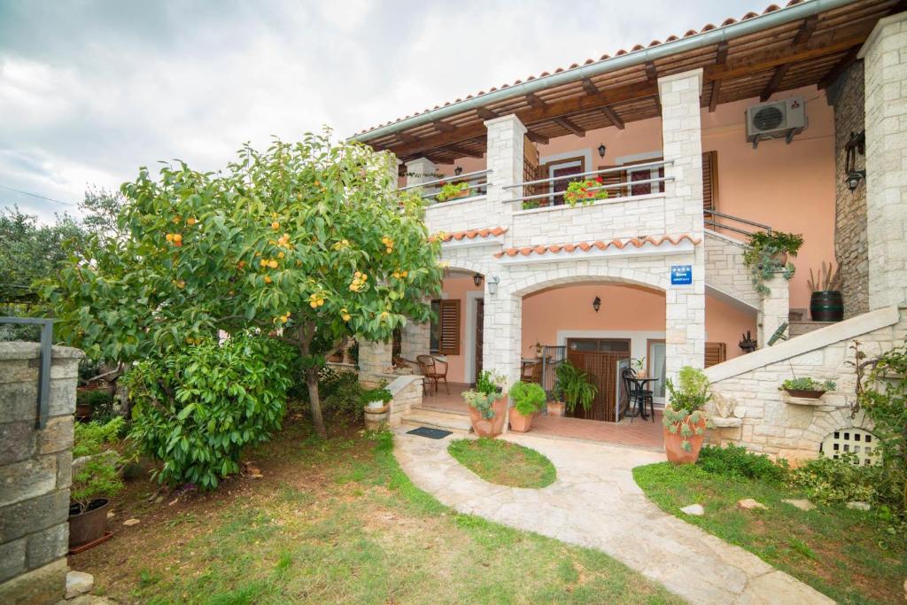 dom z drzewem pomarańczowym w ogrodzie w obiekcie Apartment Andrea 329 w mieście Vodnjan