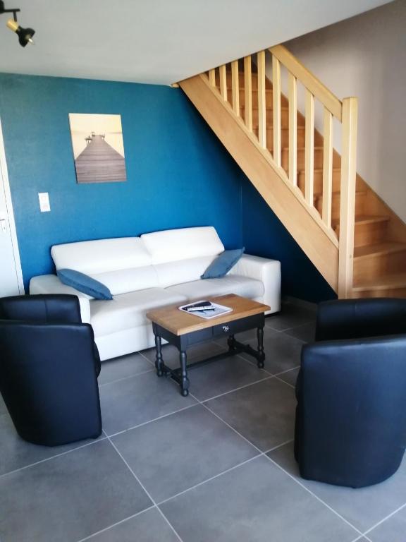 - un salon avec un canapé, une table et des escaliers dans l'établissement LE BELLEVUE 47 gîte touristique 3 étoiles, à Bricqueville-sur-Mer