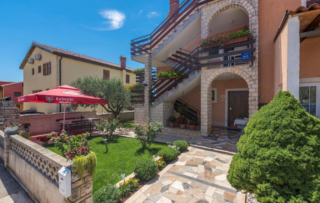 un edificio con un patio con una mesa y una sombrilla en Apartments Nerina, en Novigrad Istria