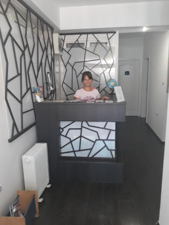 a woman standing behind a counter in a room at Mario Sunce Apartmani in Niš