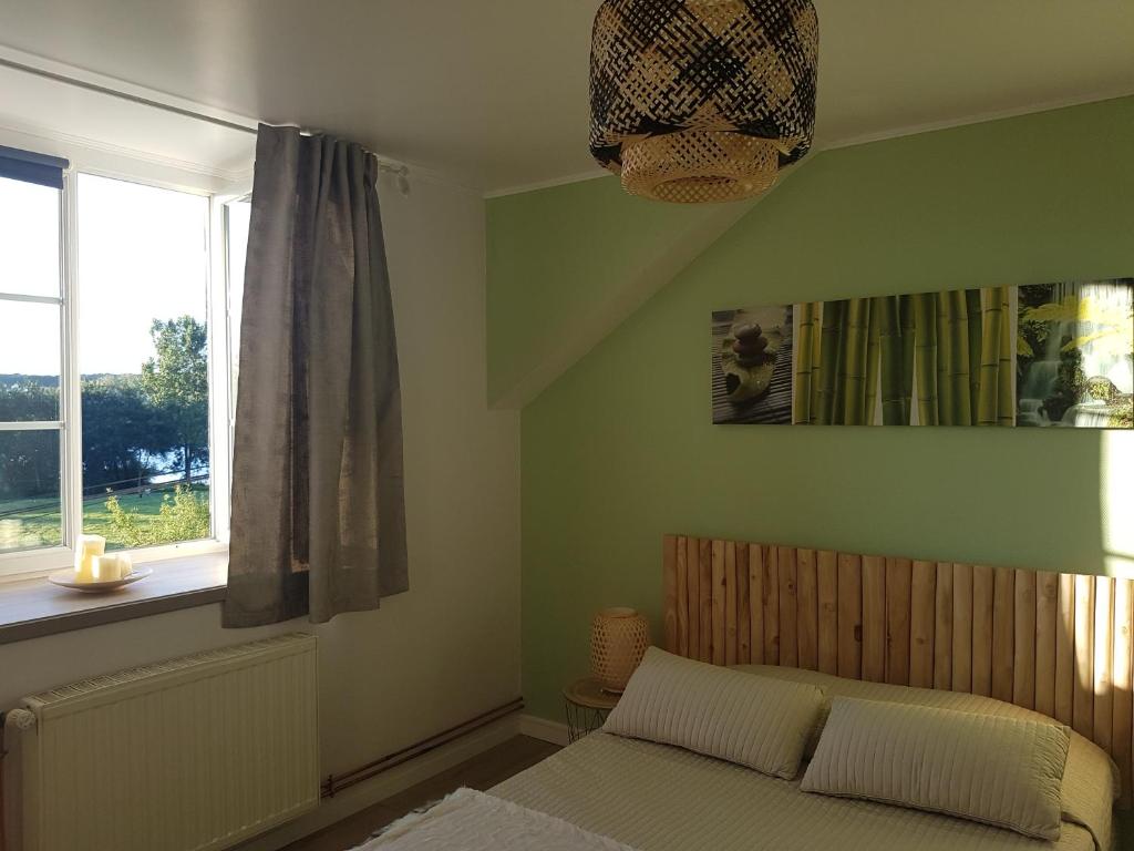 1 dormitorio con cama y ventana en Lucriolla, en Champtoceaux