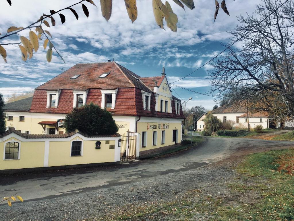 una gran casa blanca con techo rojo en un camino de tierra en Penzion u Příhodů, en Jesenice