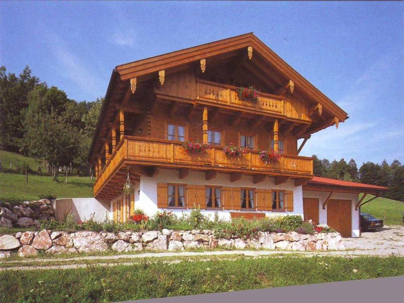 ein großes Holzhaus mit Balkon in der Unterkunft Leiterhof inkl. Chiemgaukarte in Ruhpolding