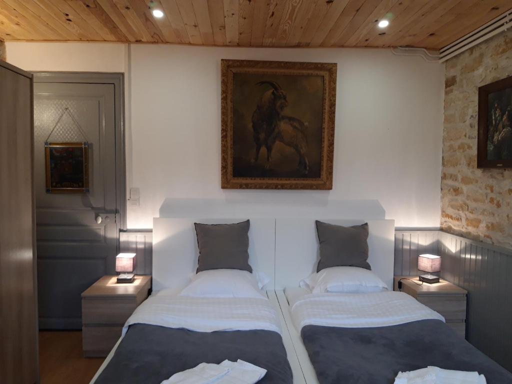 Saint-Honoré-les-BainsにあるLes Buissonnetsのランプ2つ付きの部屋のベッド2台