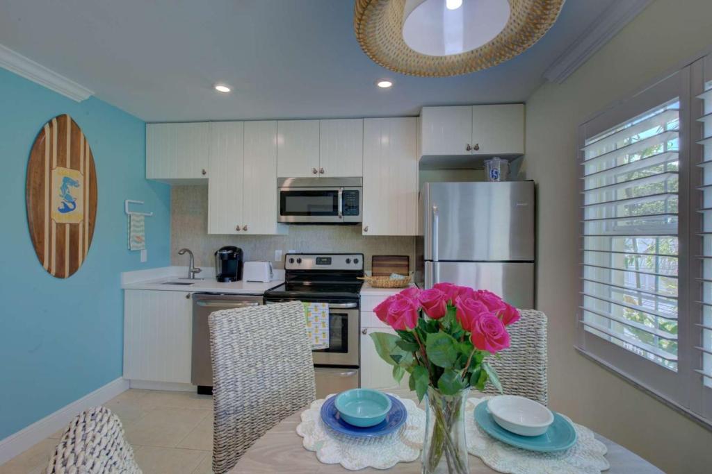 a kitchen with a table with a vase of flowers on it at LuLu's Key House Green 1/1 Upstairs in Siesta Key