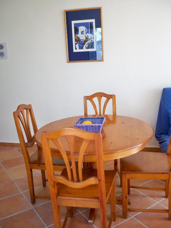 a wooden table with two chairs and a bowl on top at El Capistrano Sur in Nerja
