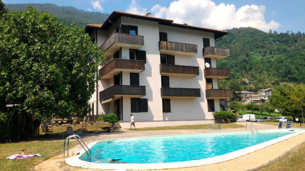 a building with a swimming pool in front of a building at Appartamento Levico lake in Levico Terme