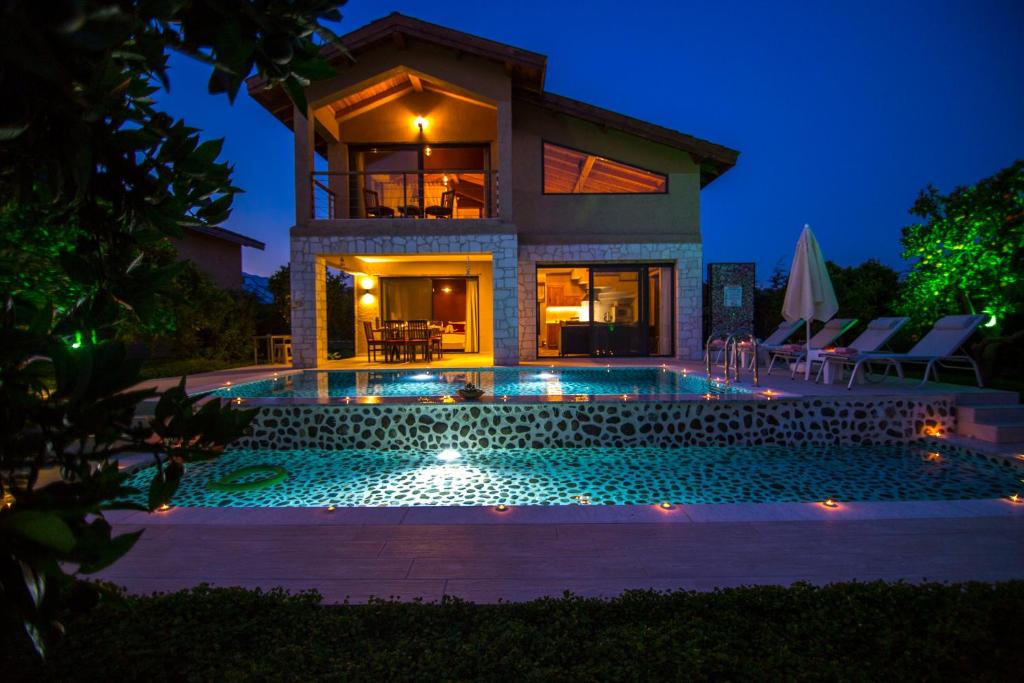 a house with a swimming pool at night at Volans Suites Villas in Fethiye