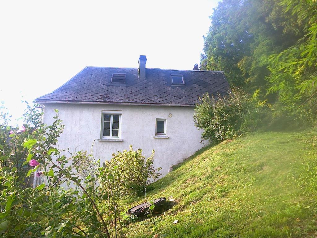 uma casa branca no topo de uma colina relvada em À flanc de colline em Cormeilles
