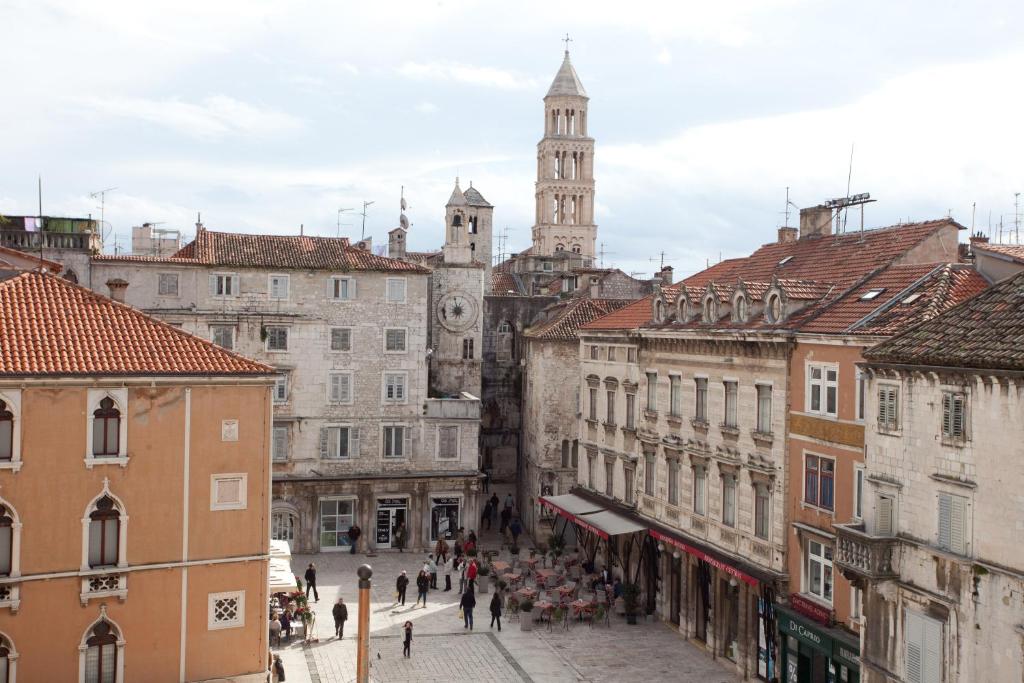 eine Stadtstraße mit einem Uhrturm in der Ferne in der Unterkunft Centar Palace Apartment in Split