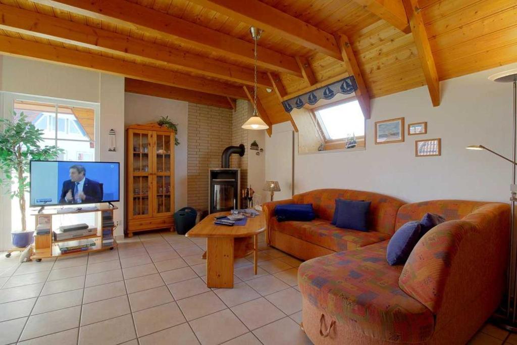 a living room with a couch and a tv at Strandvogt 2 NT13 in Dorum Neufeld