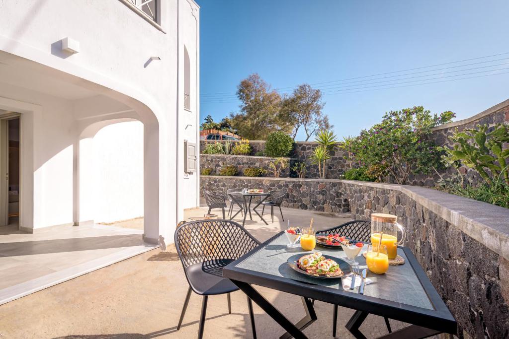 uma mesa com um prato de comida num pátio em Thealos Santorini em Pirgos