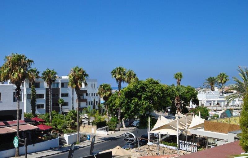 Blick auf eine Straße mit Palmen und Gebäuden in der Unterkunft Savveli by the sea in Paphos City