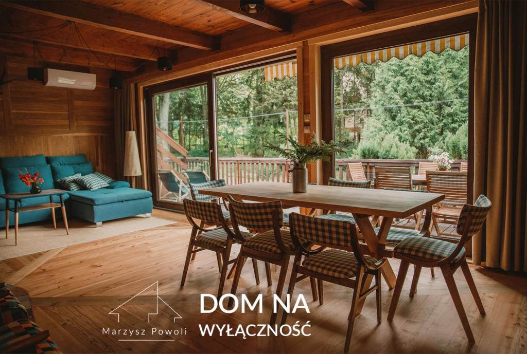 sala de estar con mesa de madera y sillas en Marzysz Powoli, en Daleszyce