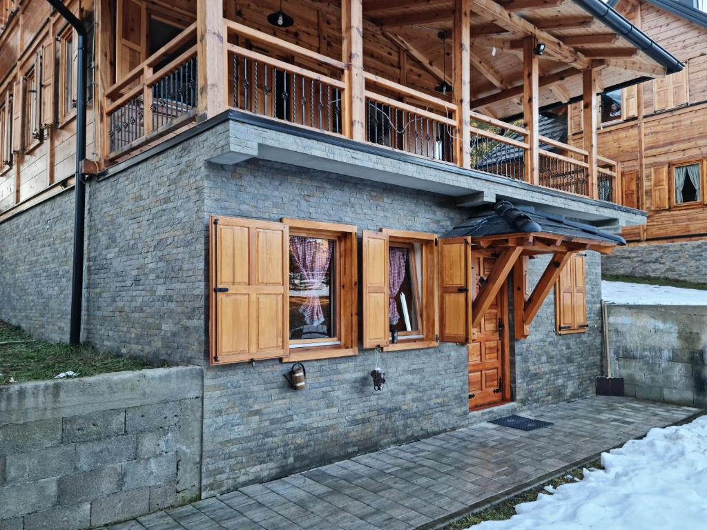 una casa con finestre in legno e balcone di tornik studio zlatibor a Zlatibor