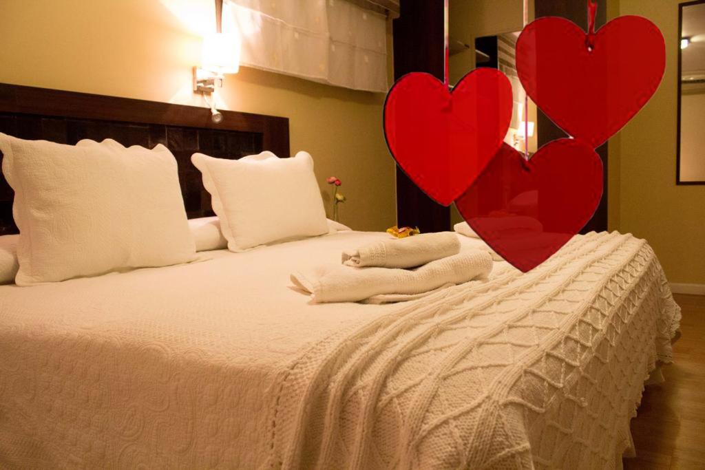dos corazones rojos sentados en la parte superior de una cama en Atankalama, en Calama