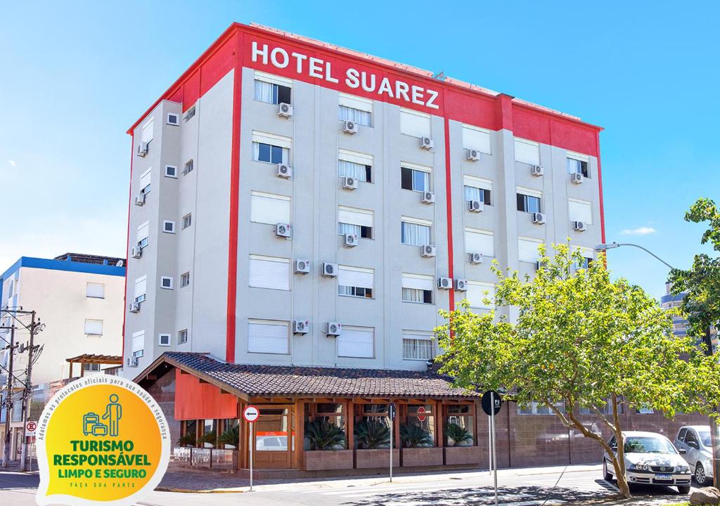 a hotel with a red and white building at Hotel Suárez Campo Bom in Campo Bom