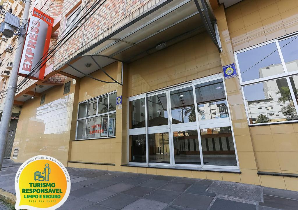 un edificio amarillo con ventanas en una calle de la ciudad en Hotel Express São Leopoldo, en São Leopoldo