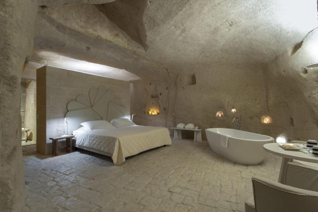 a bedroom with a bed and a tub in a room at Le Dimore Dell' Idris in Matera