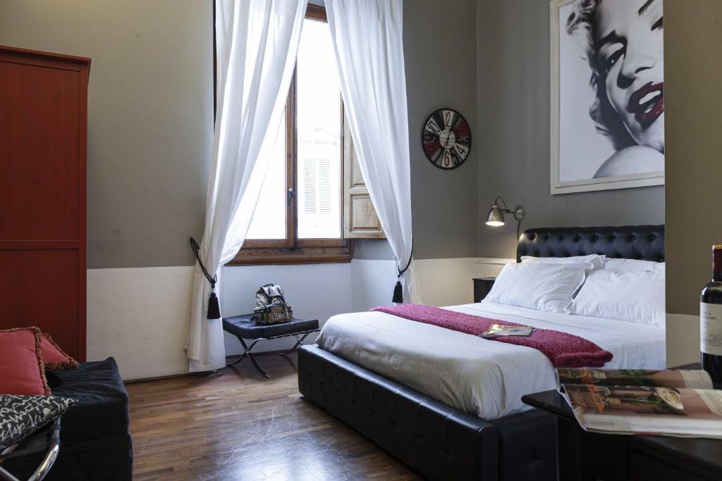 - une chambre avec un grand lit et une fenêtre dans l'établissement B&B Prestigia Rooms, à Florence