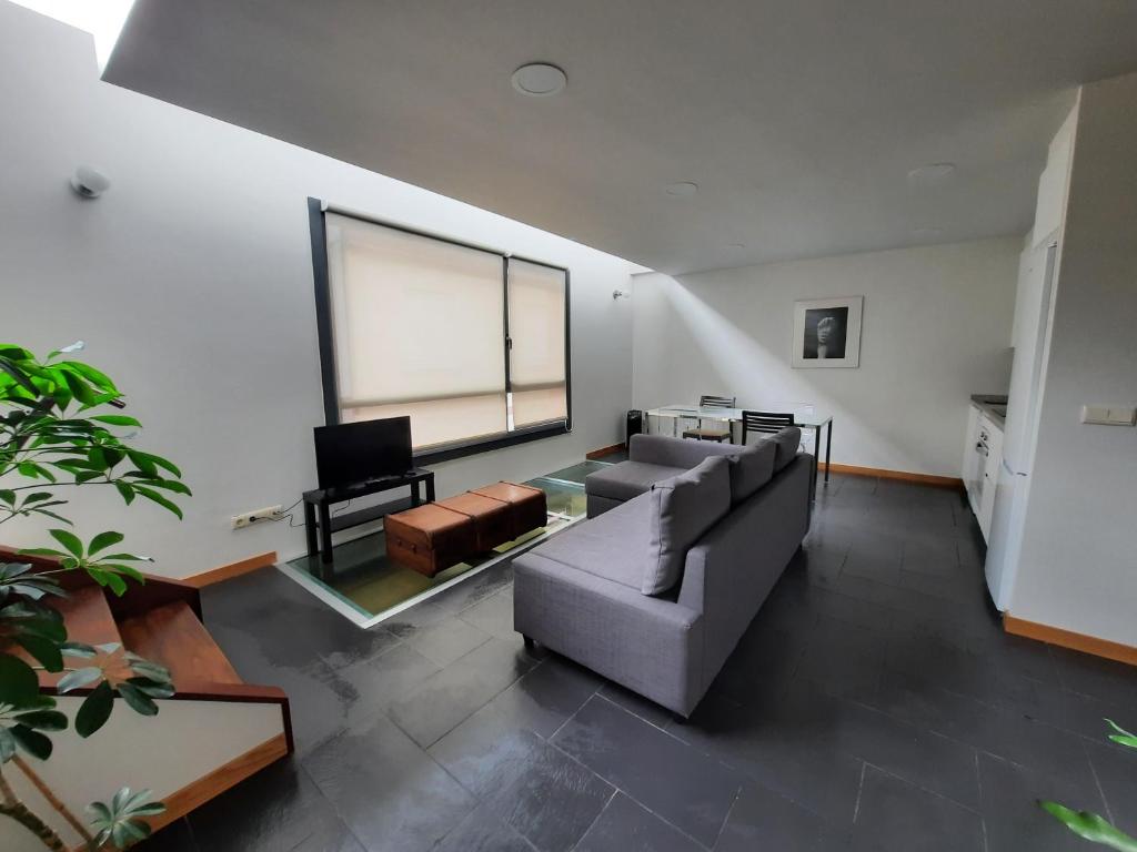 uma sala de estar com um sofá e uma grande janela em Duplex en Casas da Bríxida - Cangas do Morrazo em Cangas