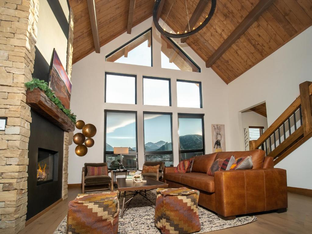 a living room with a couch and a fireplace at Beautiful Views! Jacuzzi, Indoor/ Outdoor Fireplace, Steps to Lake Estes in Estes Park