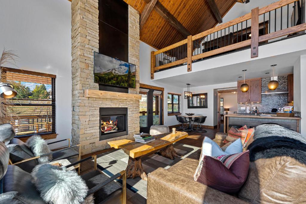 uma sala de estar com um sofá e uma lareira em Lakefront Escape Two Large Patios, Jacuzzi and Indoor Outdoor Fireplace em Estes Park