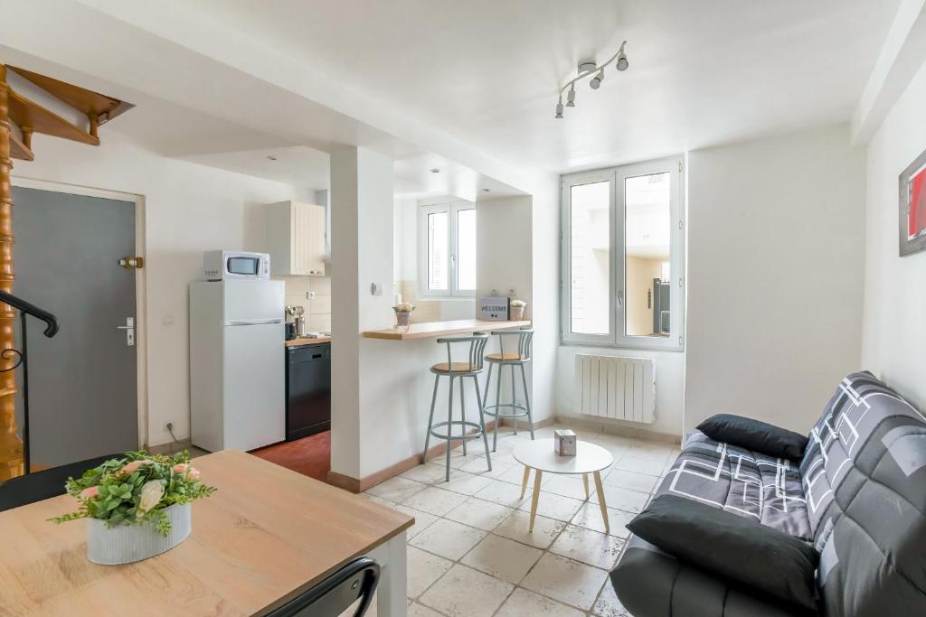 uma sala de estar com um sofá, uma mesa e uma cozinha em L'Arpajonnais 1 Cosy Hyper Centre 5min N20 em Arpajon