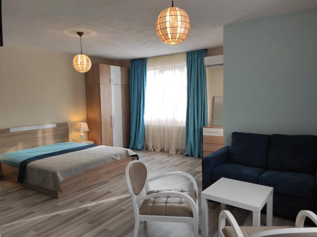 een slaapkamer met een bed en een blauwe bank bij BeLApartment in Petrich