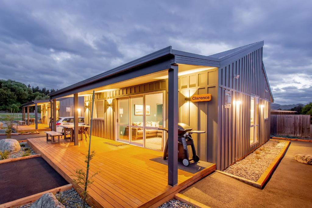 une petite maison avec une terrasse munie d'une moto. dans l'établissement Hanmer Springs TOP 10 Holiday Park, à Hanmer Springs