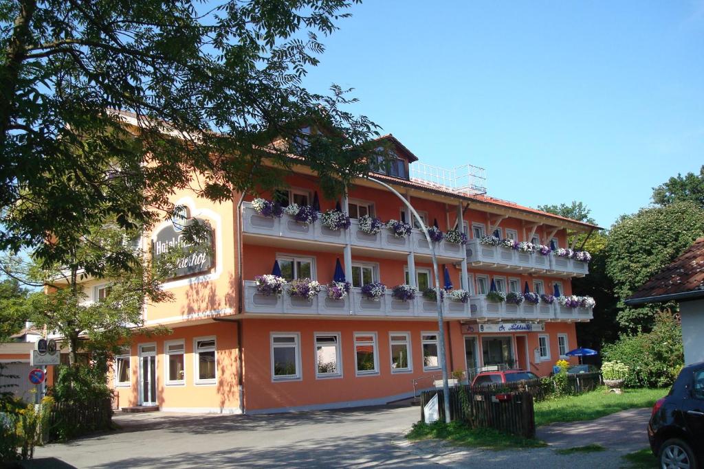 ein großes orangenes Gebäude mit Blumenkästen drauf in der Unterkunft Hotel Gasthof Seefelder Hof in Dießen am Ammersee