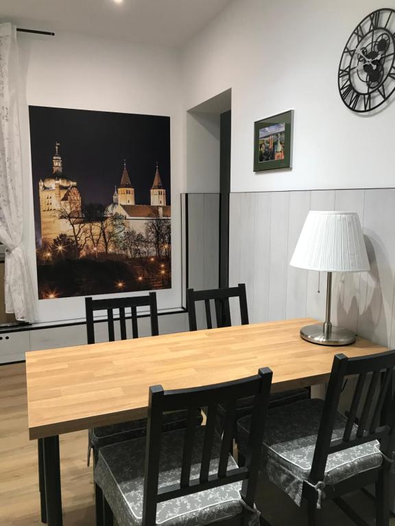 uma sala de jantar com uma mesa de madeira e cadeiras em Płock by night em Płock