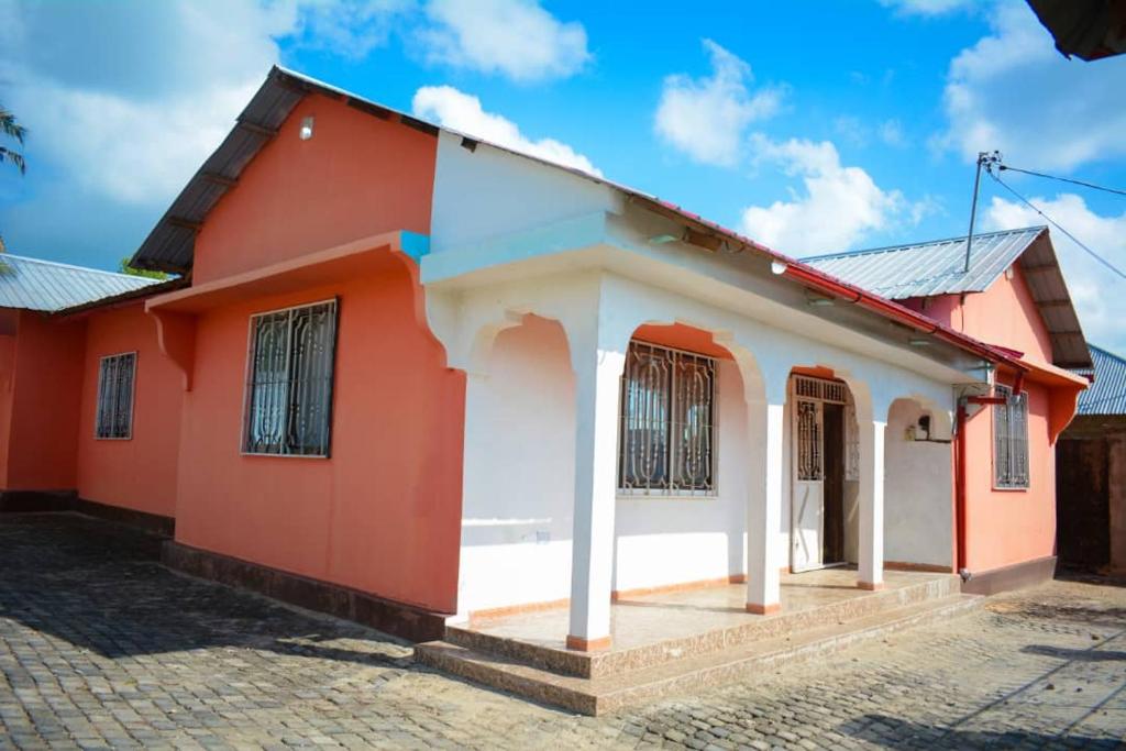 a red and white house with a cob at Mkoani Guest House in Mkoani