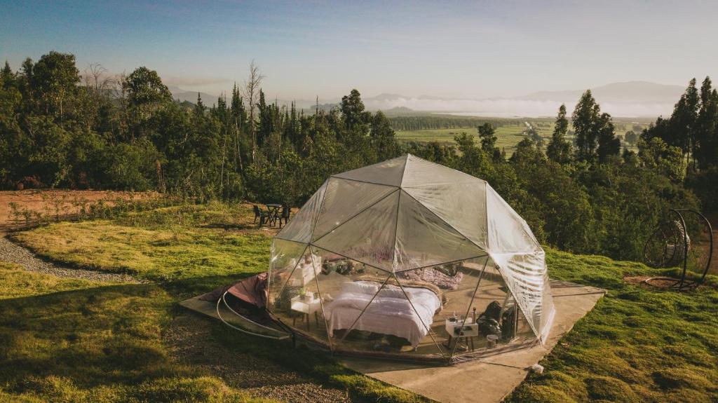 Zelt mit einem Bett auf einem Feld in der Unterkunft Sky Glamping Colombia in Fúquene